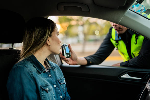 istock Young woman doing driver alcohol test on street 2207832752