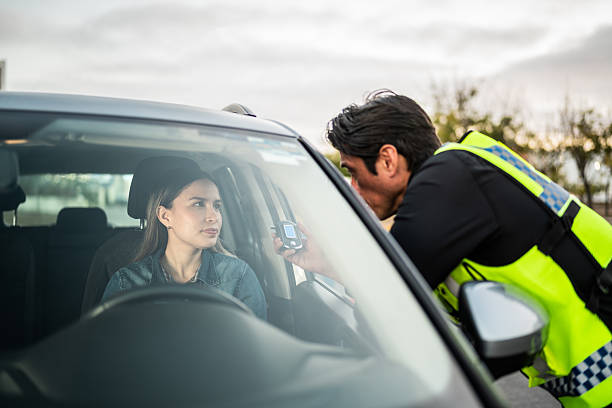 Young woman talking to traffic cop inside car