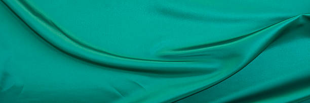 istock Black green satin dark fabric texture luxurious shiny that is abstract silk cloth background with patterns soft waves blur beautiful. 2207833553