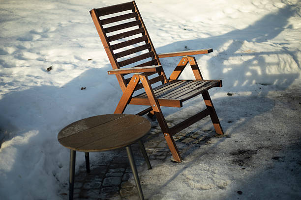 A table outside in the winter. An empty table in the yard. A place for resting outside in winter.