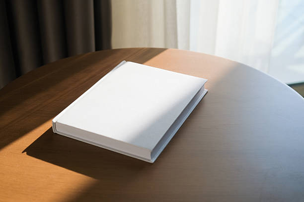 istock blank book mockup on wooden coffee table , shadow overlay 2207836260