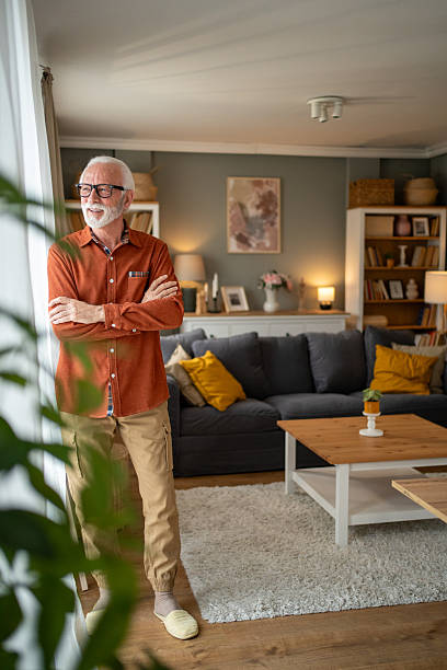 istock Senior man relaxing at home, looking out the window 2207839022