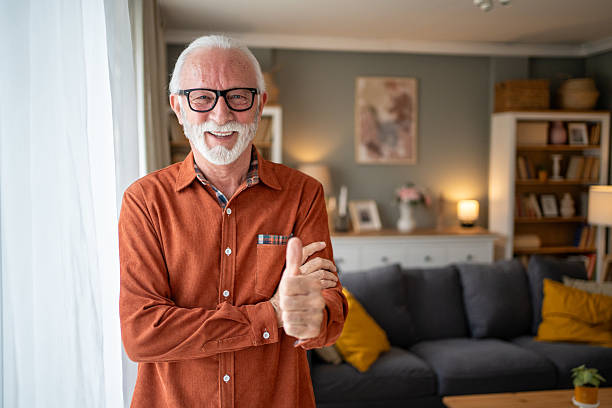 istock Happy senior man gesturing thumbs up at home 2207839037