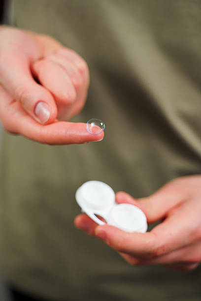 istock Eyesight correction with optical lens. Closeup contact lens for vision correction in hands. 2207840066