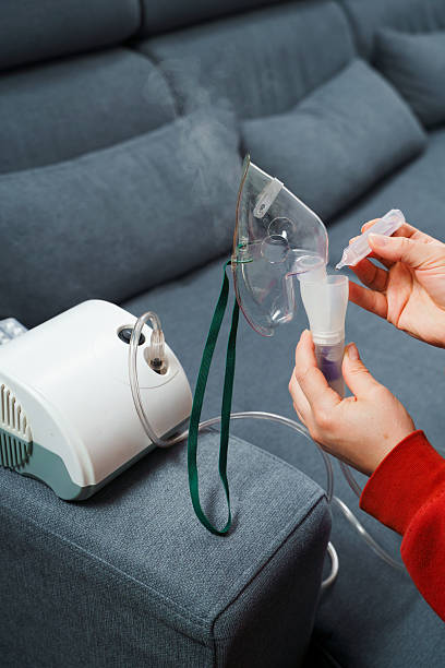 istock Dripping medical solution for inhalation treatment. Process of preparing compressor nebulizer before use at home. 2207840186