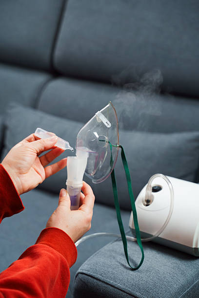 istock Dripping medical solution for inhalation treatment. Process of preparing compressor nebulizer before use at home. 2207840188