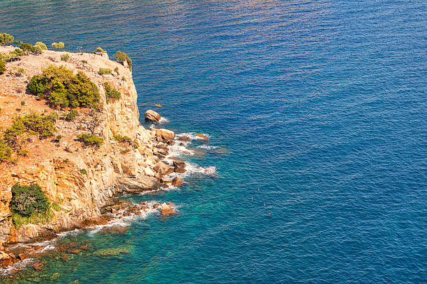 Kayakers paddling along Aegean shore at a beautiful sunny day