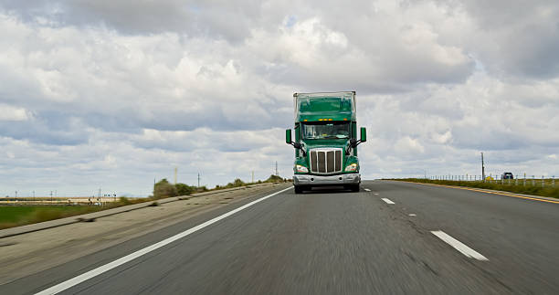 istock Green Truck Driving on Interstate 5 on Overcast Day 2207842820