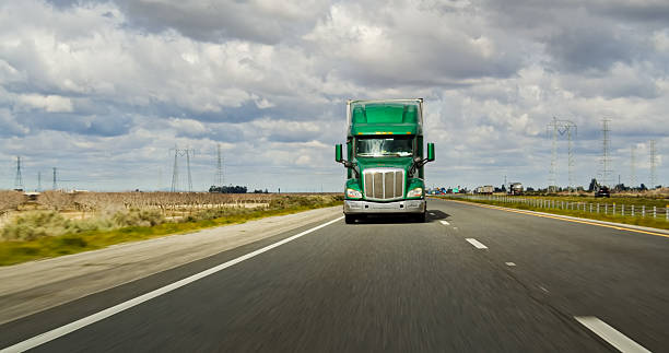 istock Green Truck Driving on Interstate 5 on an Overcast Day 2207842826