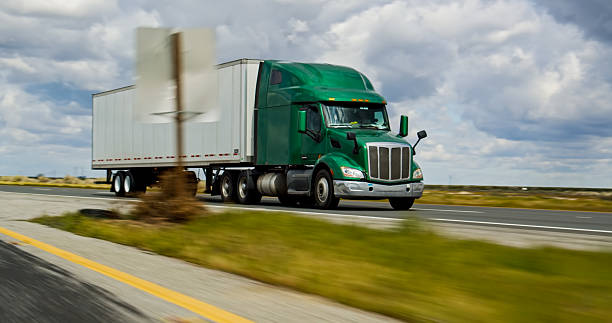 istock Green Cargo Truck Exiting Interstate 5 in CA on an Overcast Day 2207842835