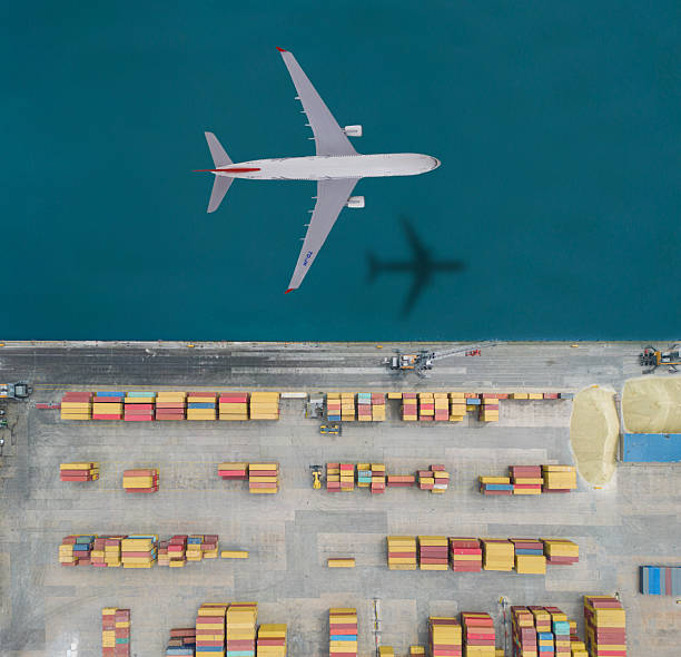 istock Airplane flying over the international container port 2207844775