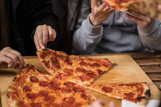 istock Friends share a pepperoni pizza 2207846939