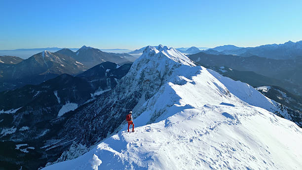 istock Snowy peak triumph: mountaineer's exhilarating accomplishment. 2207847585