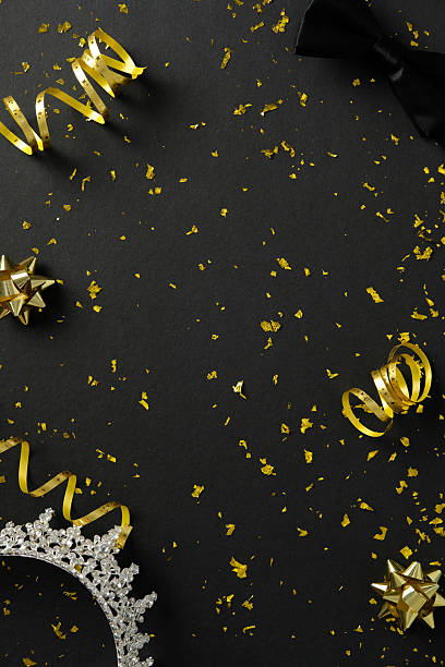 istock Prom night banner design. Top view glitter confetti and decorations, tiara, bow tie on dark background 2207849179