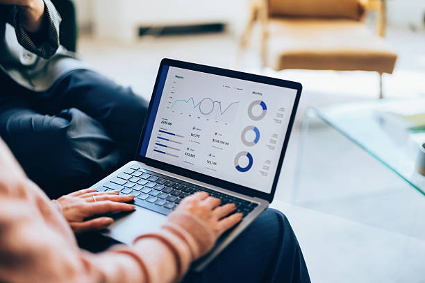 Person Analyzing Business Data on a Laptop in Modern Office Setting