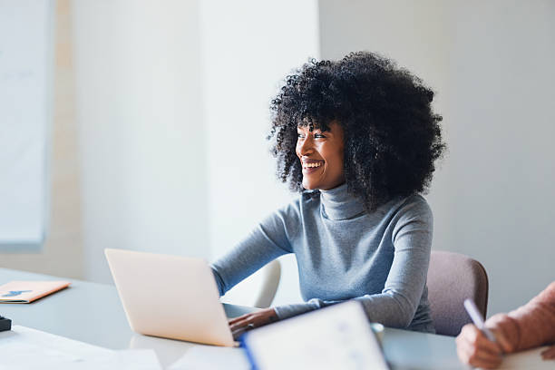 istock Smiling Professional Woman Using a Laptop During a Collaborative Office Meeting 2207850511
