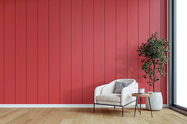 istock A minimalistic, unfurnished interior with a cozy armchair, side table  and potted plant in front of an empty red paneled accent wall background with copy space, and a window 2207851991