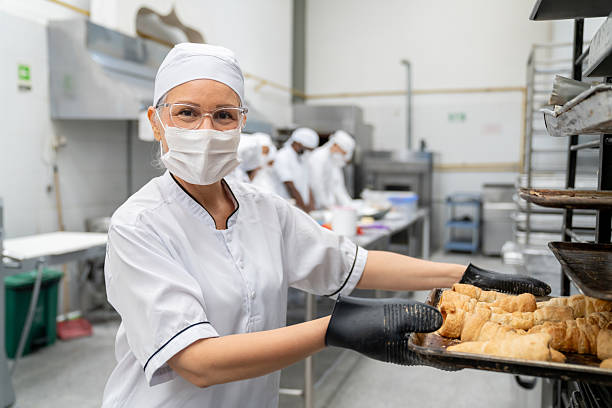 istock Baker moving a tray of bread while working at a food processing plant 2207852419
