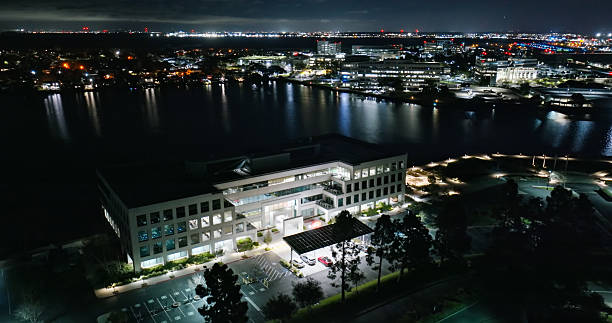 Aerial shot of illuminated nondescript Silicon Valley office buildings surrounded by parking lots at night in Redwood City, California. \n\nAuthorization was obtained from the FAA for this operation in restricted airspace.