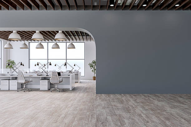 istock Semi-empty office interior with arched medium gray wall and copy space,  a wooden slats ceiling, work desks and large windows, on wood look tiled floor 2207852941