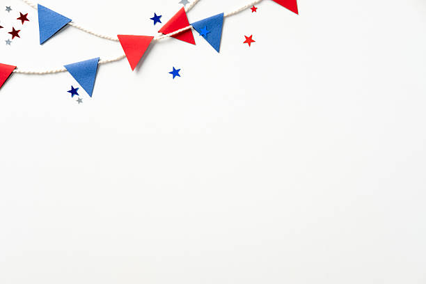 istock Colorful, patriotic party setup with red and blue flags and star confetti on a plain white background. Perfect for festive celebrations, holidays, or themed events 2207855587