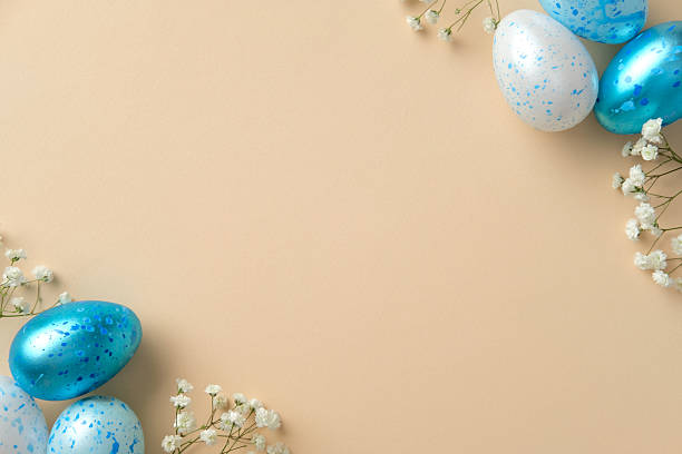 istock Blue and white speckled eggs and delicate white flowers against a soft beige background. Ideal for Easter, spring, and seasonal designs 2207855696