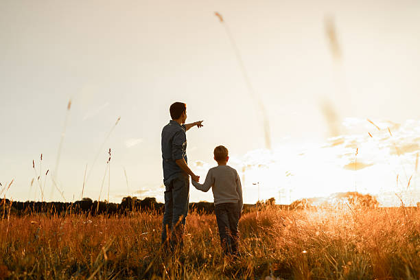 istock Father and child son walking through a meadow 2207857854
