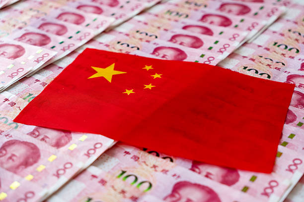 istock Interest rate cut concept illustration. Banknotes and flags were exposed multiple times. Close-up of Chinese flag and Chinese yuan combined. inflation. 2207863240