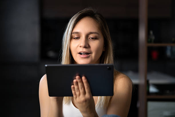 istock Woman study on tablet computer in the evening at home. A young beautiful student girl communicates online via a tablet at night in the dark. 2207863292