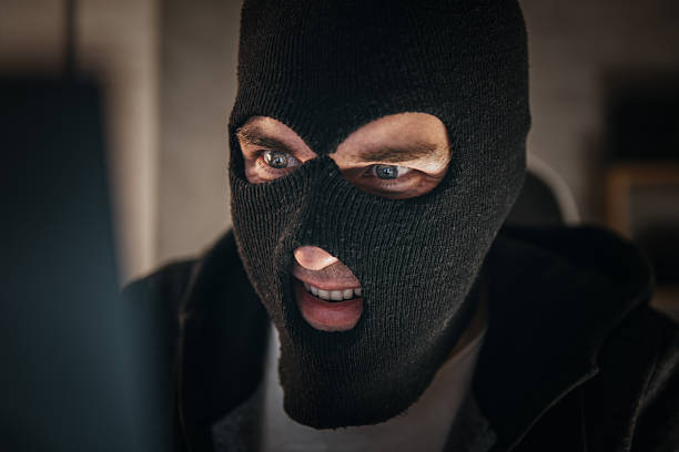 istock Thieves hold credit cards using laptop computer for password hacking activities. Cyber crime concepts. a male thief holds a credit card in his hand and picks up a password to steal money 2207863423