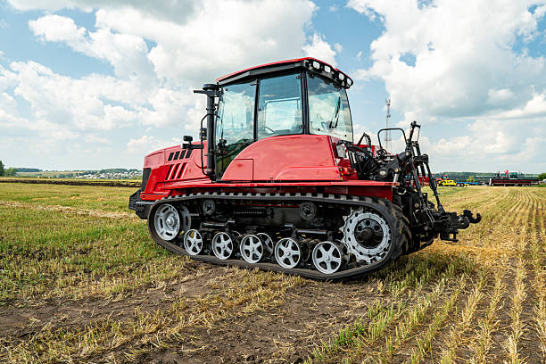 istock Red crawler tractor working in a field on a bright sunny day. The concept of work in a fields and agriculture industry. 2207863467