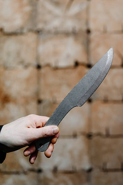 istock metal knife in wooden target 2207863720