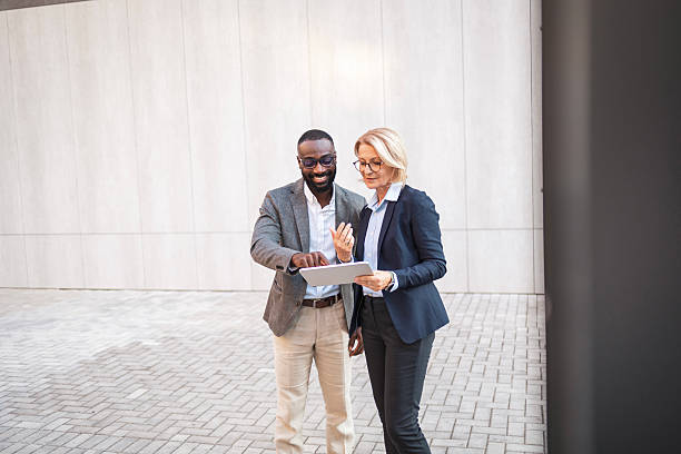 istock Professional colleagues discussing work outside modern office building 2207865048