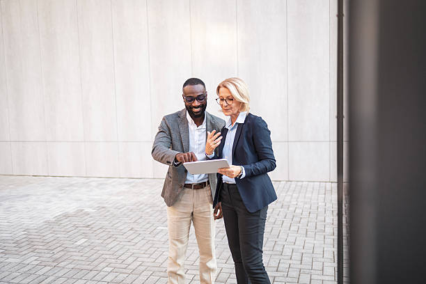 istock Business professionals collaborating on a digital tablet outdoors 2207865055
