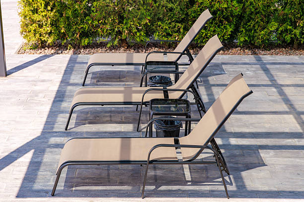 istock Three lounge chairs are sitting on a patio 2207866024