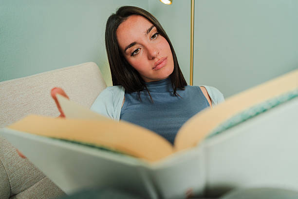 istock A thoughtful woman immersed in a captivating book, lost in her imagination while enjoying a moment of tranquility and reflection in her comfortable space, embracing the joy of reading and exploration 2207866571