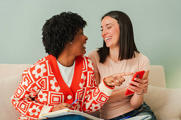 istock Two cheerful women sharing a joyful moment while using a smartphone to explore mobile applications and enjoy a delightful conversation filled with laughter and excitement together 2207869355