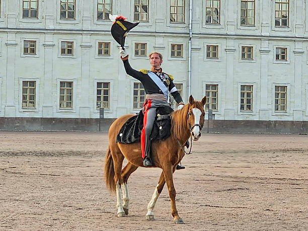 Gatchina, Russia. March, 30, 2025: Reconstruction of the Battle of Borodino, the emperor actor, Nikolai 1 on horseback greets the audience against the background of the palace.