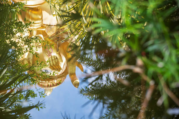 Golden ganecha reflection on water pond with greenery plant at at Wat Mae Ya Som Temple, Sa Kaeo Province, Thailand. Famous travel destination in Siam.