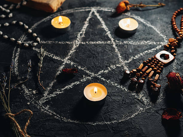 istock Black magic ritual with pentagram symbol, burning candles and amulets 2207873700