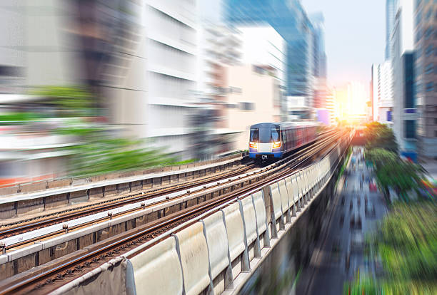 istock Electric skytrain speeding through city at sunset 2207874621