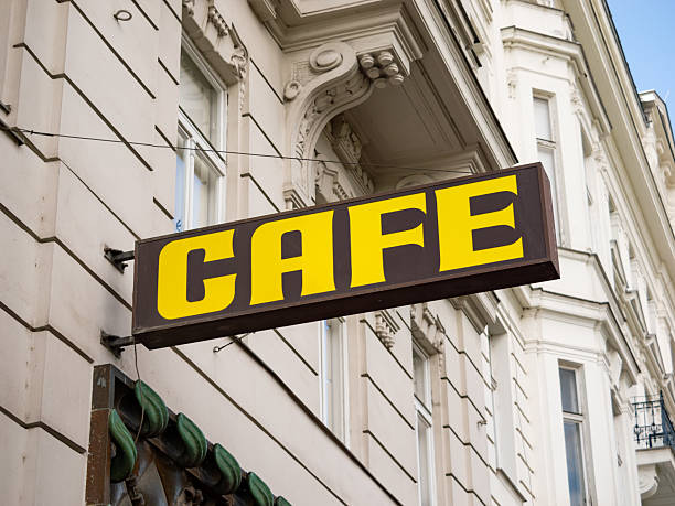 istock Cafe Sign in Yellow Color on a Building Facade 2207875321