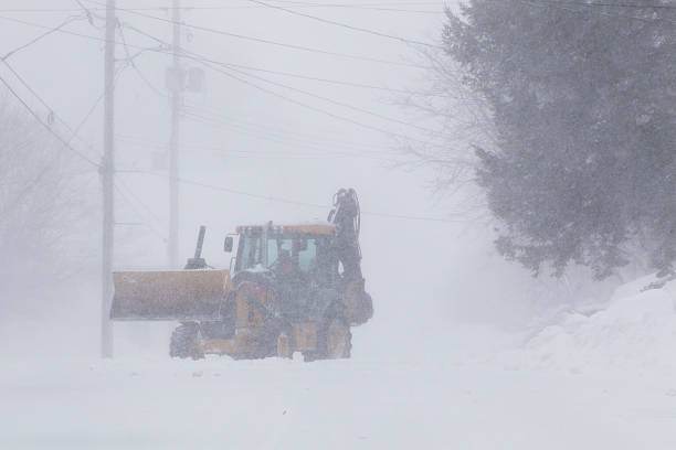 istock Snow removal tractor on a small town road during a heavy blizzard. 2207877705