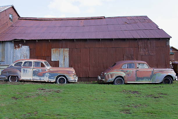 istock Two Abandoned Vintage Car by a Barn 2207886391