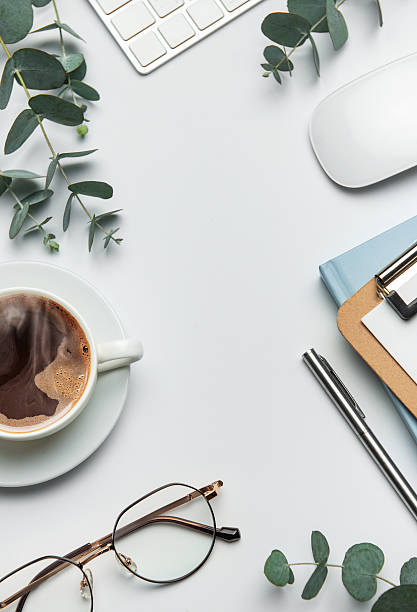 istock Eucalyptus branches, coffee, keyboard, and mouse framing white desk background 2207889331
