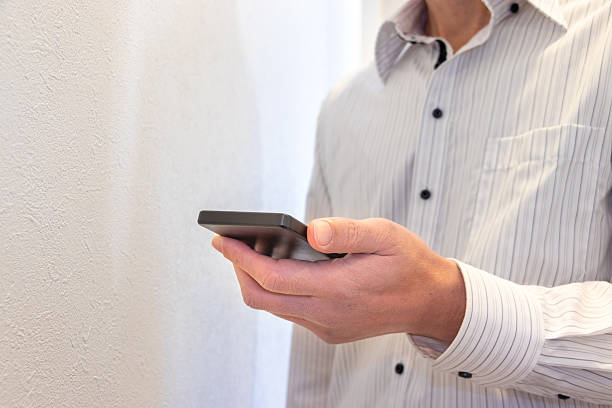 istock A man in a white shirt holding a smartphone 2207891597