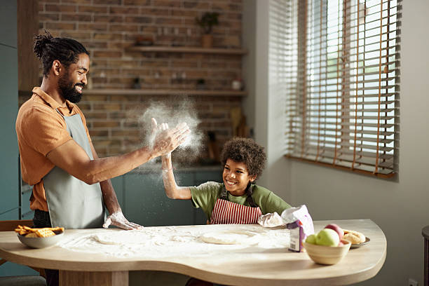 istock Happy black father and son having fun while making a cake in the kitchen. 2207892918
