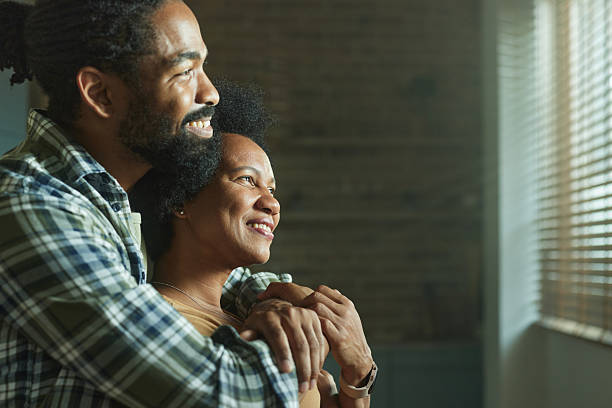 istock Happy black couple day dreaming embraced at home. 2207894916