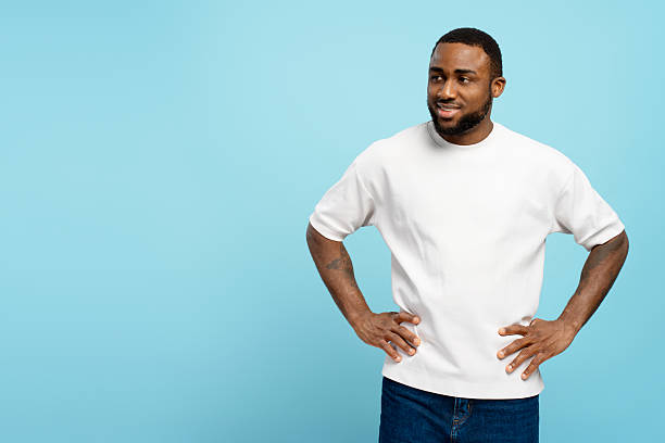istock Handsome African American man looking away and smiling with hands on hips on blue background 2207895024