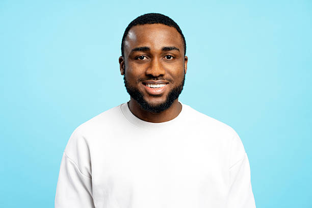 istock Smiling, handsome African American man smiling on blue background: studio portrait 2207895025